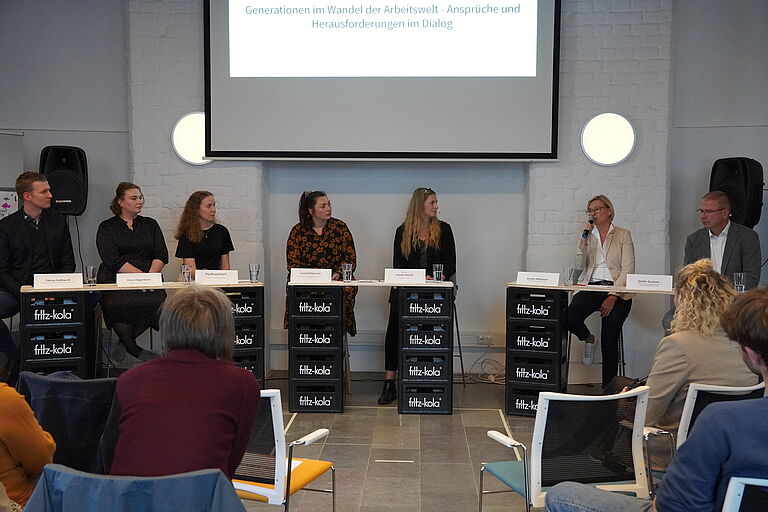 Das Bild zeigt mehrere Menschen nebeneinander stehend - die Podiumsdiskussion. 