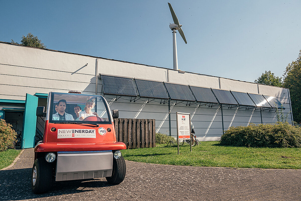 Student*innen fahren mit dem Wasserstoffbetrieben Caddy aus dem Institut für Regenerative Energien. 