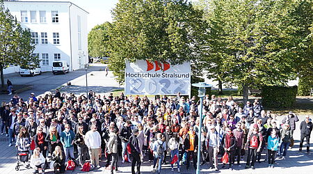 Das Bild zeigt eine sehr große Gruppe junger Menschen - die neuen Studierenden von 2022 - vor einem HOST-Schild mit der Jahreszahl 2022