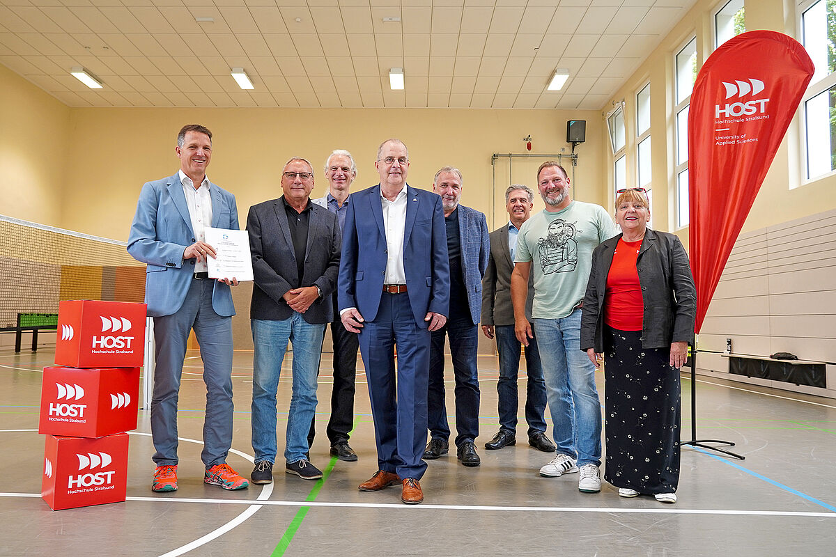 8 Personen, welche nach der Unterzeichnung in der Sporthalle sich zum Gruppenfoto aufgestellt haben.