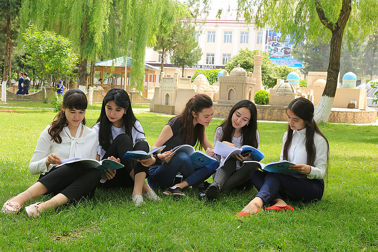 Studentinnen sitzen vor der Tashkent State University of Economics