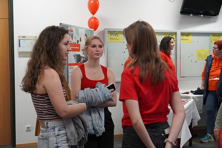 zwei junge Frauen im Gespräch mit einer Studentin