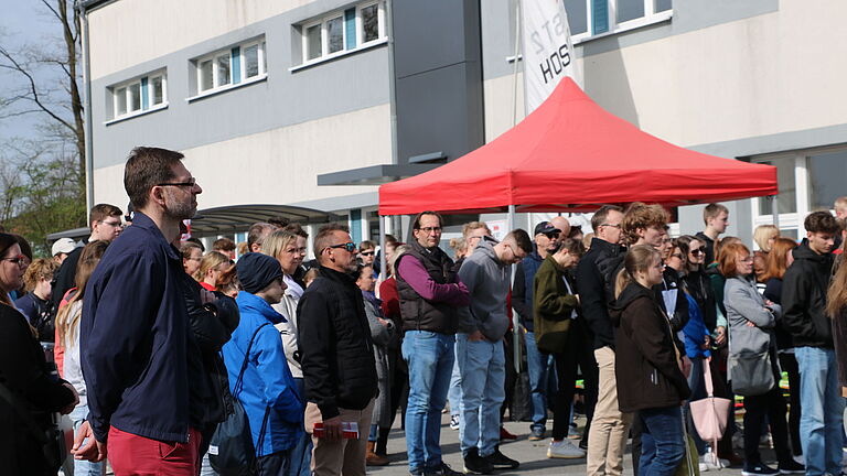 eine Gruppe von Menschen im freien, die einer rede lauschen