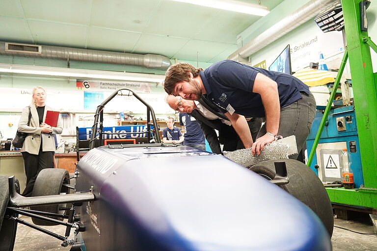 Ein Student, Ole Panzer, und Staatssekretär Jochen Schulte am TY23 des Baltic Racing Teams.