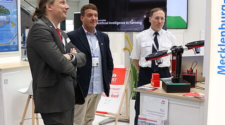 Drei Männer an einem Messestand: Prof. Dr.-Ing. Mark Vehse, Christian Tokaji, Prof. Dr.-Ing. Jens Ladisch