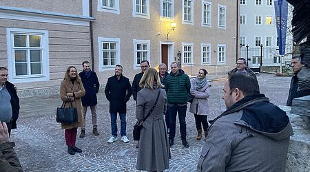 Eine Gruppe von Menschen, darunter die Ministerin, steht in einer Stadt..