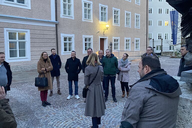 Eine Gruppe von Menschen, darunter die Ministerin, steht in einer Stadt..