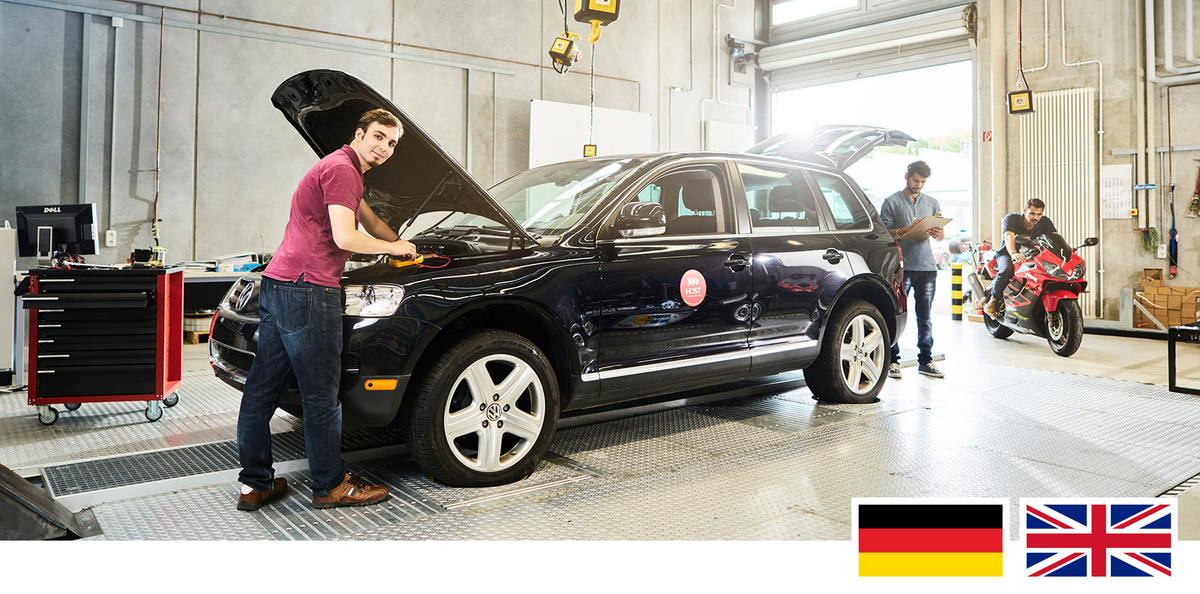 Headerfoto: Studierender steht vorne am Auto bei einer geöffneten Motorraumklappe