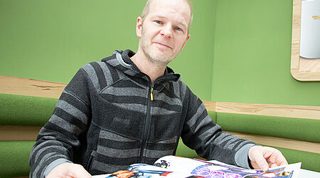 Prof. Szepannek beim Comic lesen in der Cafeteria