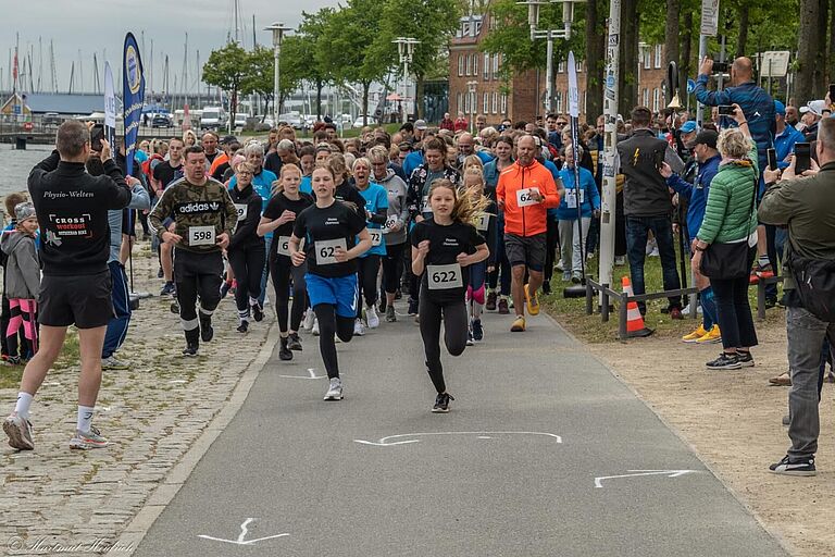 Der Start eines Laufs (2024 Hospizlauf), vorn ein junges Mädchen, hinten die Hafenkulisse