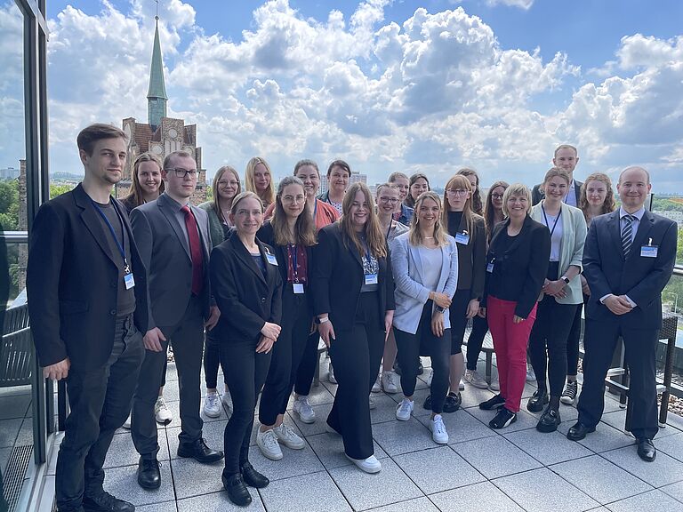 Gruppenfoto mit vielen lächelnden Menschen - das Team der HOST