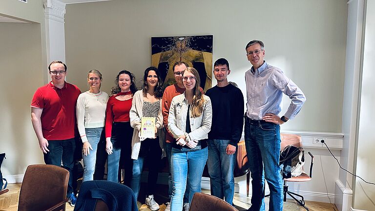 Ein Gruppenbild von Studierenden und Prof. in einem Büro