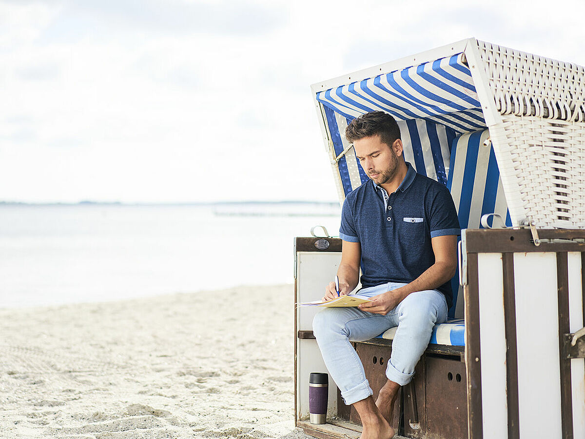 Student lernt im Strandkorb direkt am Strand.