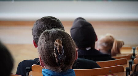 Die Hinterköpfe von jungen Menschen in einem Hörsaal