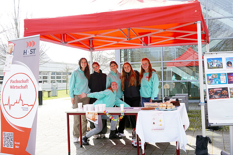 junge fröhliche Frauen an einem roten Info-Stand